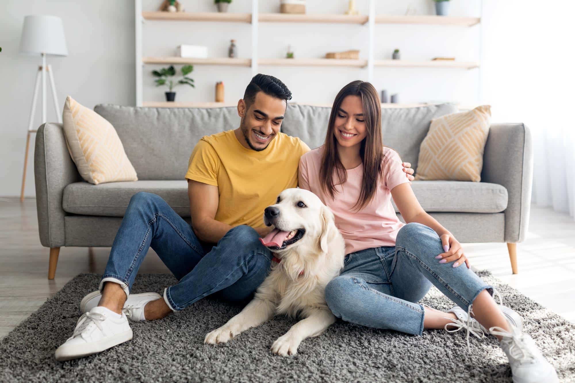 Couple with their dog in the living room.